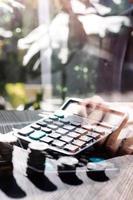 concetto di contabilità aziendale, uomo d'affari che utilizza la calcolatrice con computer portatile, budget e carta di prestito in ufficio. foto