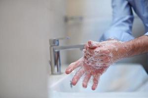 coronavirus maschio waving mani nel bagno foto