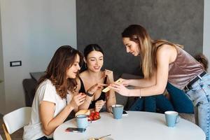 tre donna amici prima colazione nel il cucina foto