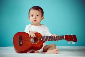 un' bambino giocando ukulele foto
