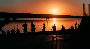 persone siamo riposo su un' gli sport campo di il fiume banca foto