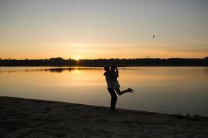 coppia nel Alba su il spiaggia foto