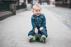 poco divertente ragazzo con skateboard su il strada foto