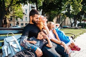 bellissimo giovane famiglia riposo su un' panchina foto