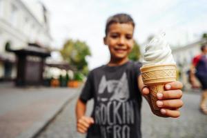 contento bambino mangiare ghiaccio crema su un' estate giorno foto