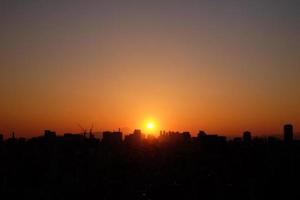 sole che tramonta sulla città di tokyo foto