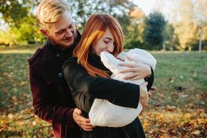 giovane famiglia e neonato figlio nel autunno parco foto