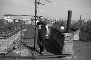 l'uomo con gli stivali e i jeans autentici fa la cimossa sul tetto dell'edificio nel centro storico foto