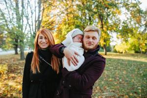 giovane famiglia e neonato figlio nel autunno parco foto