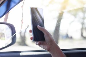 il mano di autista è utilizzando un' mobile Telefono per Aiuto navigare o GPS mentre parcheggio su il lato di il strada. foto