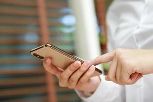 vicino su mano giovane donna nel Guardando Messaggio su mobile inteligente Telefono durante rompere. utilizzando cellula telefoni per comunicare nel il in linea mondo. con vuoto o vuoto nero schermo foto