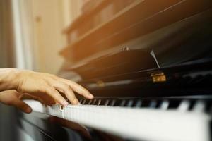 primo piano della mano persone uomo musicista che suona la tastiera del pianoforte con i tasti di messa a fuoco selettiva. può essere utilizzato come sfondo. foto