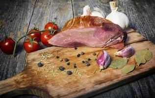 carne di maiale affumicata con erbe e spezie su tavola di legno foto