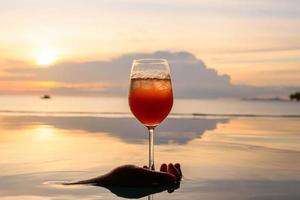 un' cocktail nel il vino bicchiere al di sopra di nuoto piscina. bellissimo scena riflessione acqua. foto