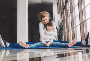 madre e figlia abbracci e allungare nel il Palestra foto