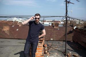 l'uomo con gli stivali e i jeans autentici fa la cimossa sul tetto dell'edificio nel centro storico foto