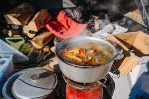 la minestra bollente su bruciatore, cucinando cibo all'aperto su gas Jet foto