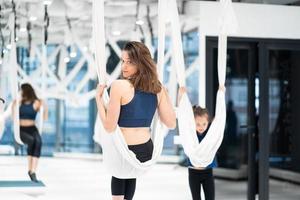 volare yoga. giovane donna pratiche aereo anti gravità yoga foto