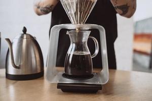 vicino su di un' barista fabbricazione mano fermentato caffè. foto