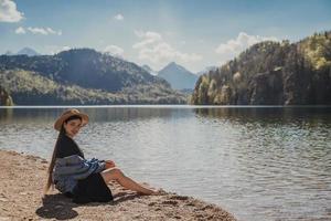 il ragazza nel il vestito e cappello di il lago nel il montagne foto