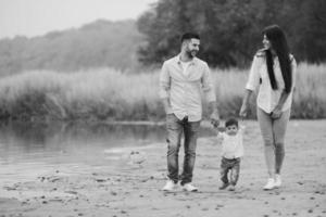 giovane famiglia a piedi a il spiaggia foto