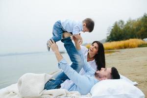 contento giovane famiglia rilassante insieme su il lago foto