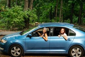 Due amiche scemo in giro e ridendo insieme nel un' auto foto