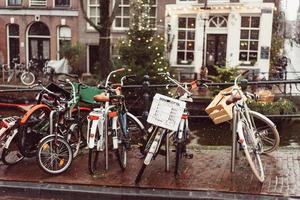 biciclette liner un' ponte al di sopra di il canali di amsterdam foto