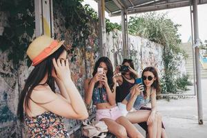 quattro bellissimo ragazze a il autobus fermare foto