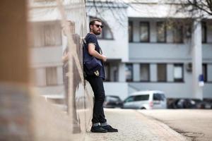 l'uomo con gli stivali autentici e i jeans a cimosa sullo sfondo della città vecchia foto