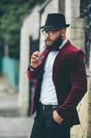 un' ricco uomo con un' barba fuma elettronico sigaretta foto
