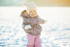 poco ragazza passeggiate nel il neve foto