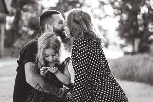 amorevole genitori camminare con loro poco figlia foto