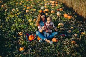 madre e figlia su un' campo con zucche foto