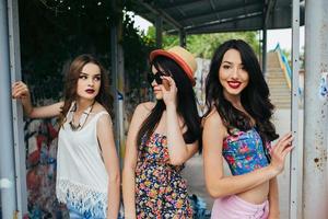 tre bellissimo giovane ragazze a il autobus fermare foto