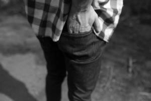 uomo Tenere il suo mano nel il indietro tasca di il suo jeans foto