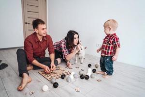 contento famiglia siamo giocando insieme su il pavimento foto