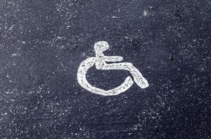 parcheggio spazi per Disabilitato clienti. parcheggio lotto con dipinto cartello di sedia a rotelle. foto