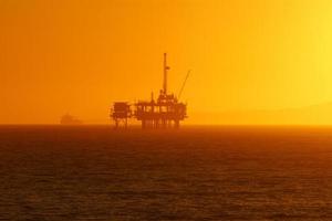 piattaforma petrolifera spiaggia al tramonto