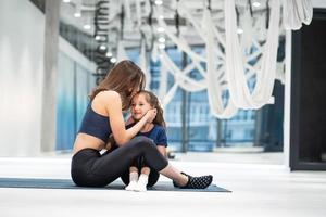 giovane adulto madre ricompense sua poco figlia con un' bacio foto