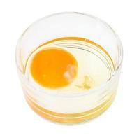 crudo uovo nel bicchiere ciotola isolato su bianca foto