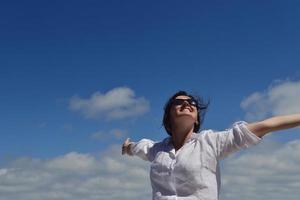 felice giovane donna con le braccia allargate al cielo foto