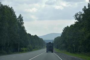 un' alta velocità strada nel il ural montagne nel Russia. carico e passeggeri trasporto su il montagna strada. foto