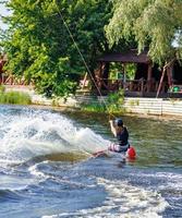 ripido girare di un' wakeboarder su un' acqua fiume superficie nel un' gli sport parco su un' estate giorno. foto