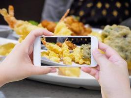 assunzione foto di gamberetto tempura su bianca piatto con smartphone