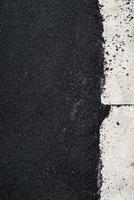 nuovo asfalto di cemento vicino al cordolo di cemento foto