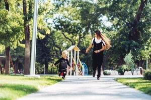 madre e poco figlio siamo a piedi nel il parco foto