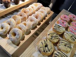 Linee di fresco delizioso ciambelle su forno negozio, gustoso multiplo ciambelle, selettivo messa a fuoco ciambelle foto