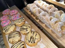 Linee di fresco delizioso ciambelle su forno negozio, gustoso multiplo ciambelle, selettivo messa a fuoco ciambelle foto