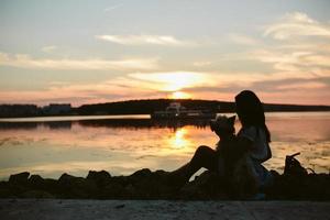 ragazza e cane su il lago foto